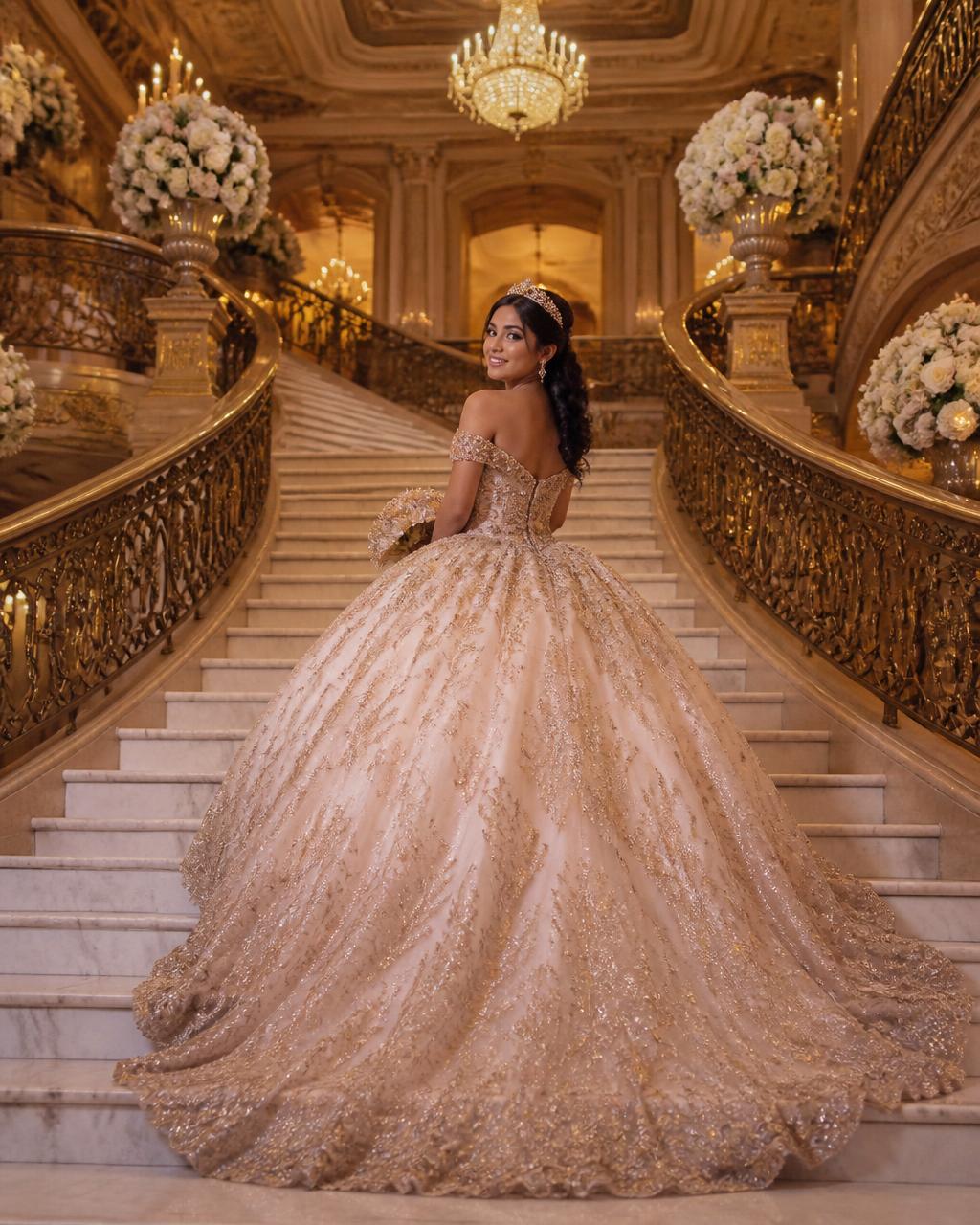 Quinceañera in a formal ball gown on the grand staircase of a luxury ballroom
